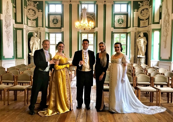 Singers in period costume standing in The Green Hall at Amorbach Abbey